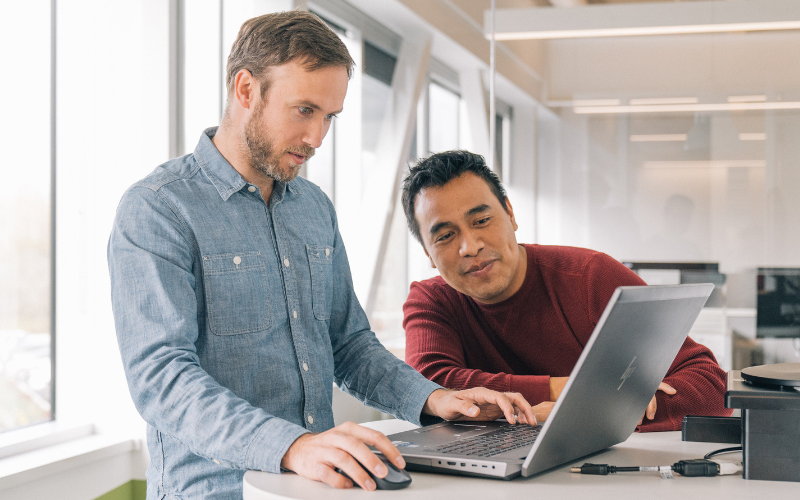 Two coworkers in front of a laptop