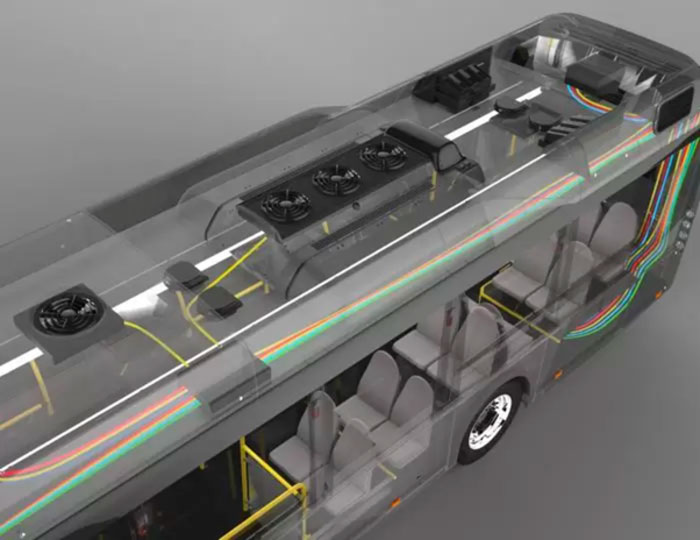 Une vue aérienne d'un modèle de bus transparent montrant son agencement intérieur et le système de câblage électrique. Le câblage est codé par couleur, visible le long des murs et du plafond, délimitant les sièges, les poteaux et l'emplacement des équipements.